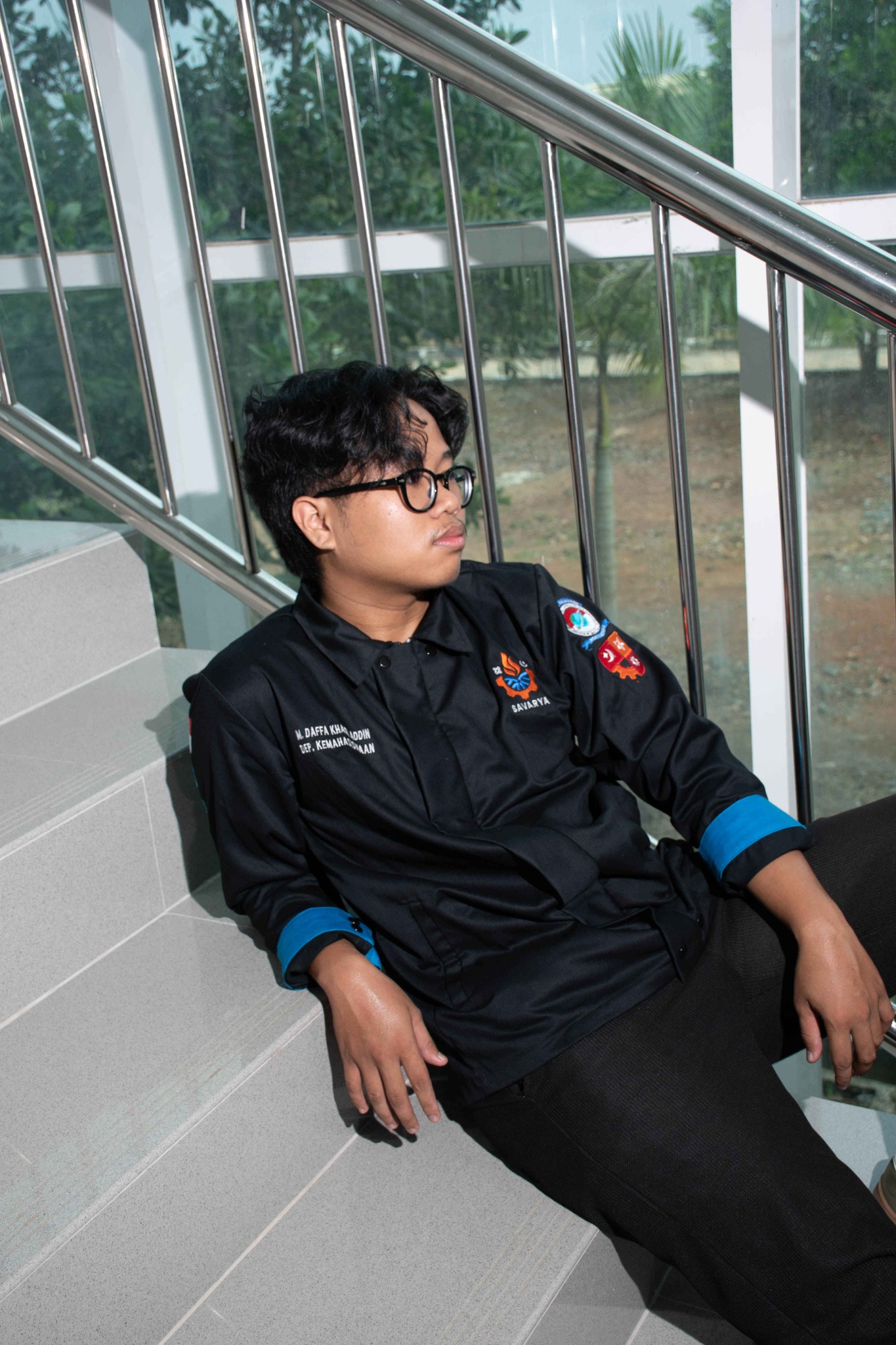 Portrait of Muhammad Daffa Khairi Addin sitting on a staircase